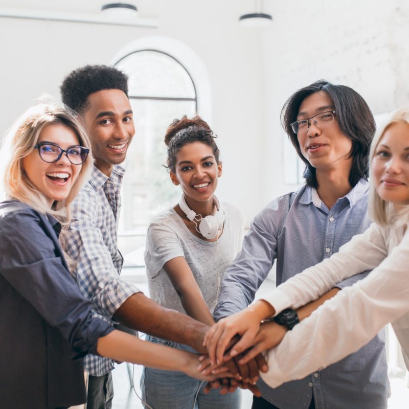 handsome-african-guy-with-happy-face-expression-supporting-his-friends-before-conference-indoor-portrait-work-team-young-international-specialists-preparing-meeting-with-chief