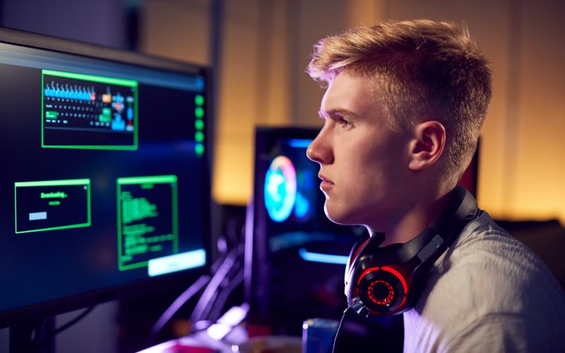 male-teenage-hacker-sitting-in-front-of-computer-screens-bypassing-cyber-security.jpg